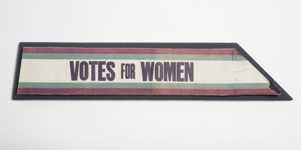 suffragette sash with 'votes for women' on it